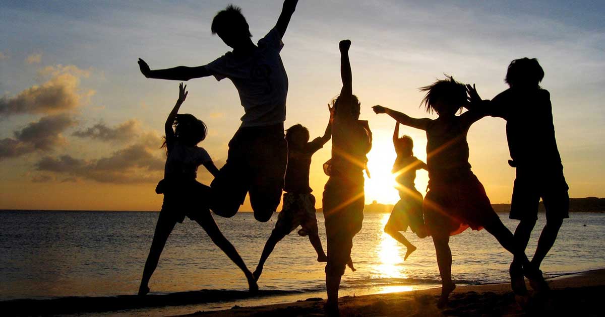 Guys dancing on the beach at sunset